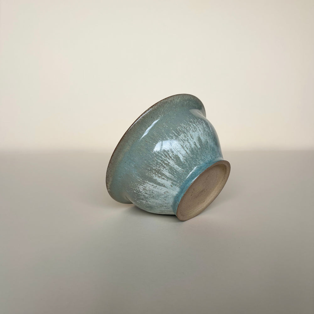 Ceramic bowl with an interesting glaze colour surface on a cream background. Pottery bowl  Handmade in Ireland. Wheel Thrown Pottery and Ceramic. 