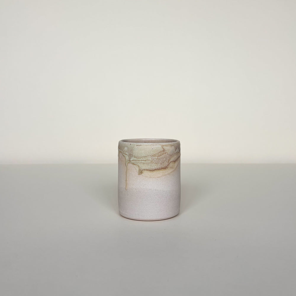 Small ceramic cup with marbled design on a light cream background.  Pottery tumbler  Handmade in Ireland. Wheel Thrown Pottery and Ceramic.