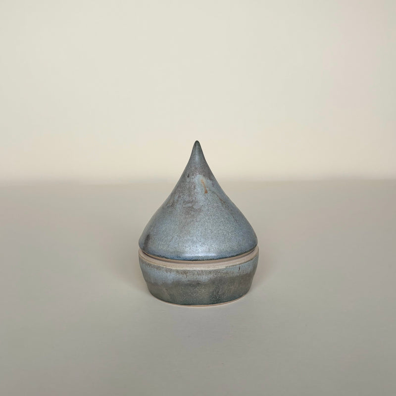 Cylindrical ceramic container with a conical top on a cream background.  Pottery  Handmade in Ireland. Wheel Thrown Pottery and Ceramic. 