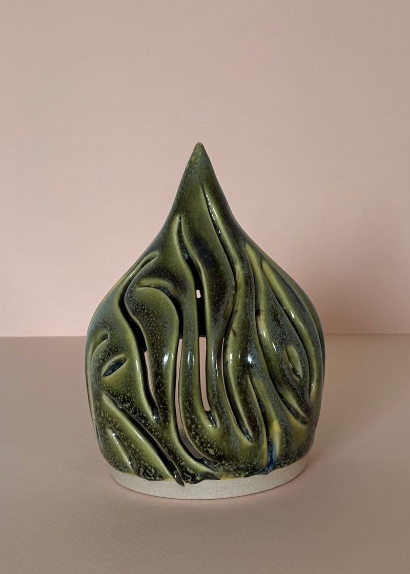 Green ceramic tea light candle holder with carved wavy design on a light pink  background. Pottery  Handmade in Ireland. Wheel Thrown Pottery and Ceramic.