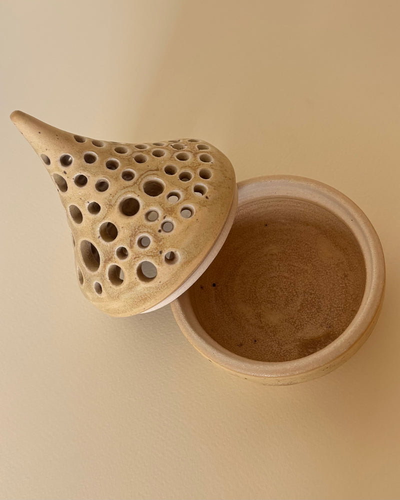 Ceramic tea light candle holder with a unique design on a beige background. Pottery  Handmade in Ireland. Wheel Thrown Pottery and Ceramic. 